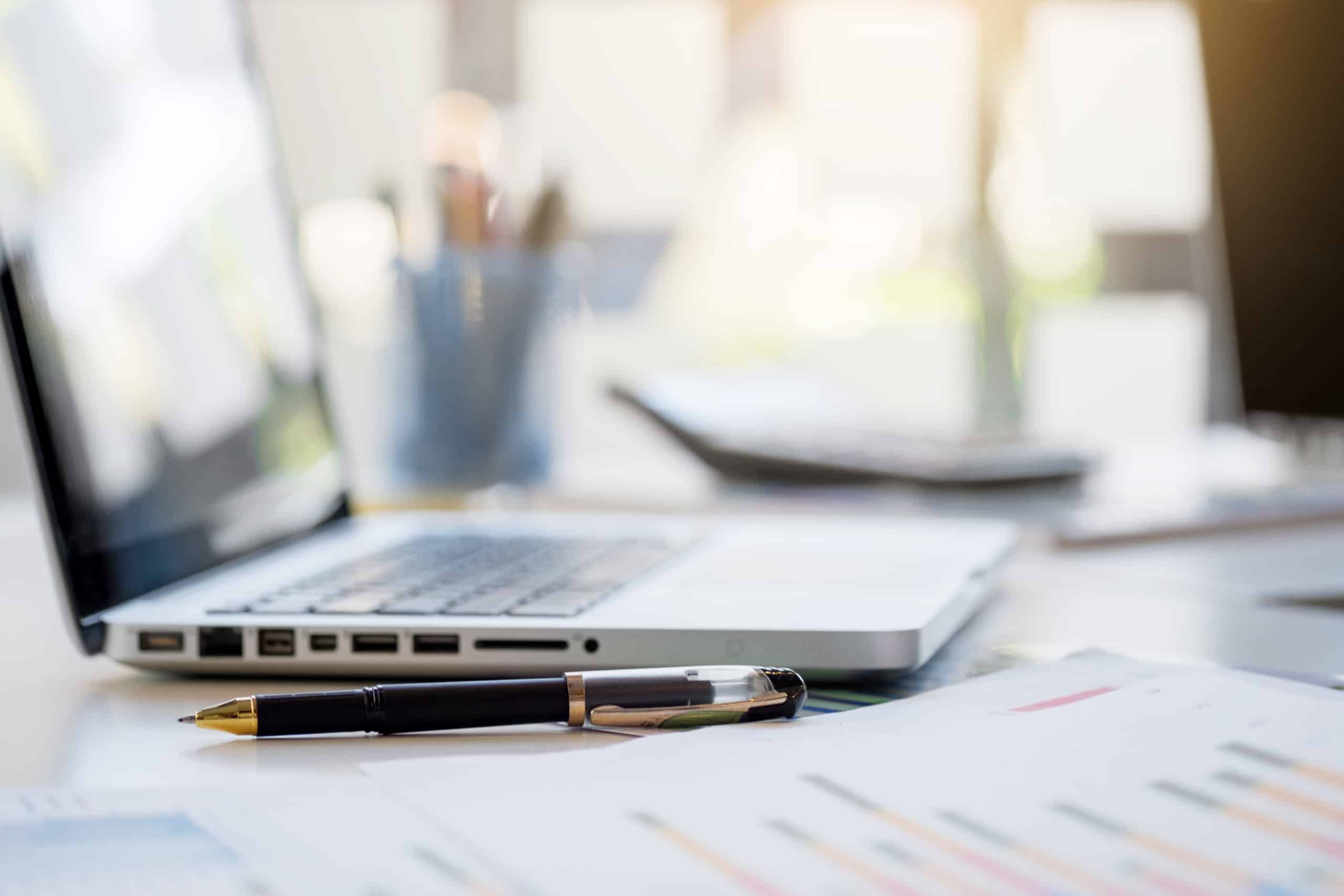 Business desk with a keyboard, report graph chart, pen and table